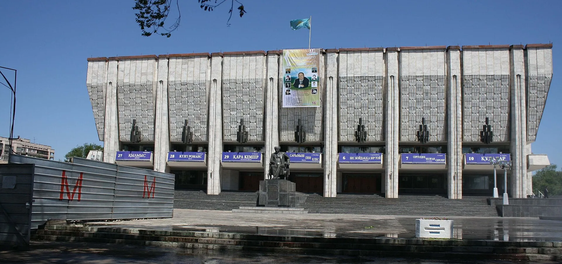 Kazakh Auezov Drama Theatre and Almaty Metro Station Tulpar (red M-letter on the left iron fence) under construction.