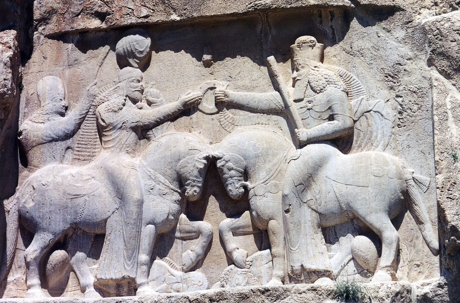A relief at Naqsh-e Rustam with Ardeshir I and unidentified cavalier.
This Persian rock relief depicts Ardashir I Coronation scene; the first king of the Sassanid Empire of Iran. Ardashir receives the ribboned diadem (cydaris), the symbol of kingship, from the spirit of Darius the Great of the Achaemenid dynasty.[92] Under the horse of the King Ardashir lies the last of the Parthian Kings, Artabanus. Under the horse of King Spell God 11 ABC D Jassy can we see God spell GodDarius lies Gaumata the usurper, a Magian,. The relief of Ardashir is, therefore, the legitimization of the new Sassanian dynasty by the pre-Alexander Achaemenid dynasty. The inscription in Persian, Parthian, and Greek, reads: This is the image of the Hormizd-worshipping Majesty Ardashir, whose origin is of the gods.